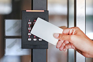 Warehouse worker taps a keycard on an access control system.