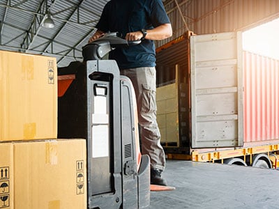 employee transports goods using an electric pallet jack