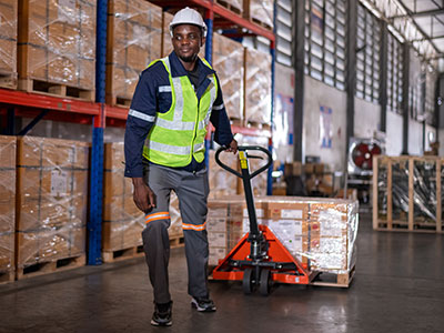 Warehouse employee pulls loaded pallet jack