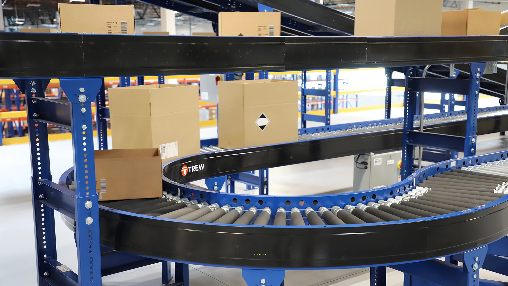 automated-conveyor-systems-trew.png Close-up of an automated conveyor line transporting boxes in a warehouse